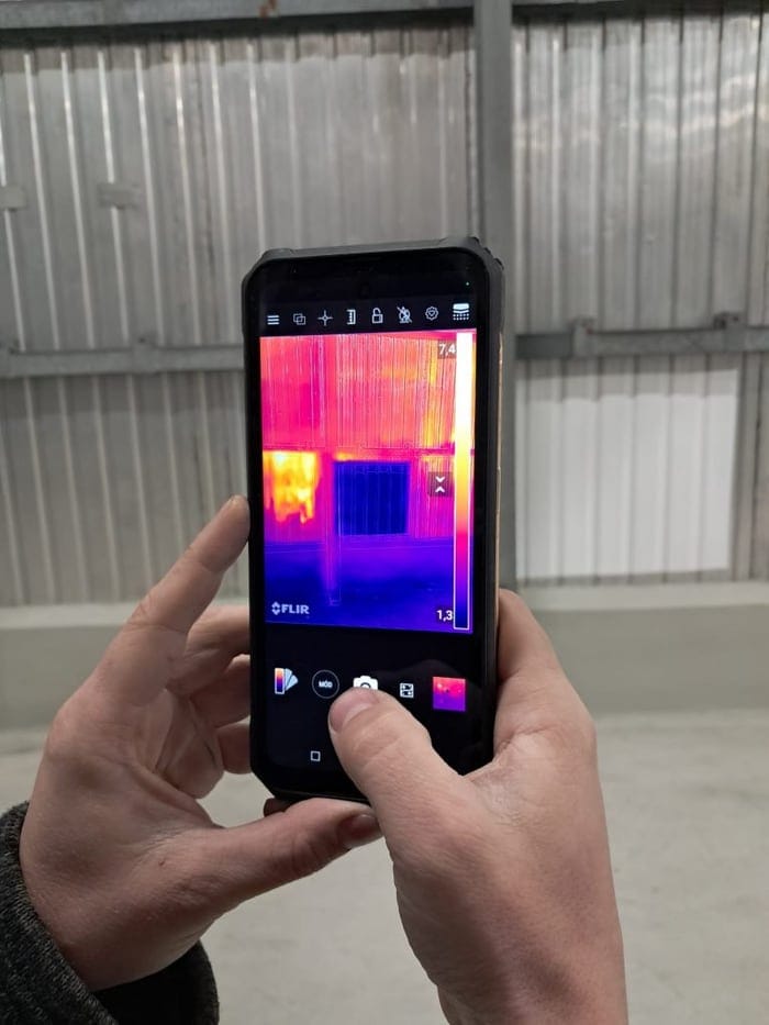 FLIR thermographic inspection inside a metal-clad industrial building — visual documentation of heat distribution